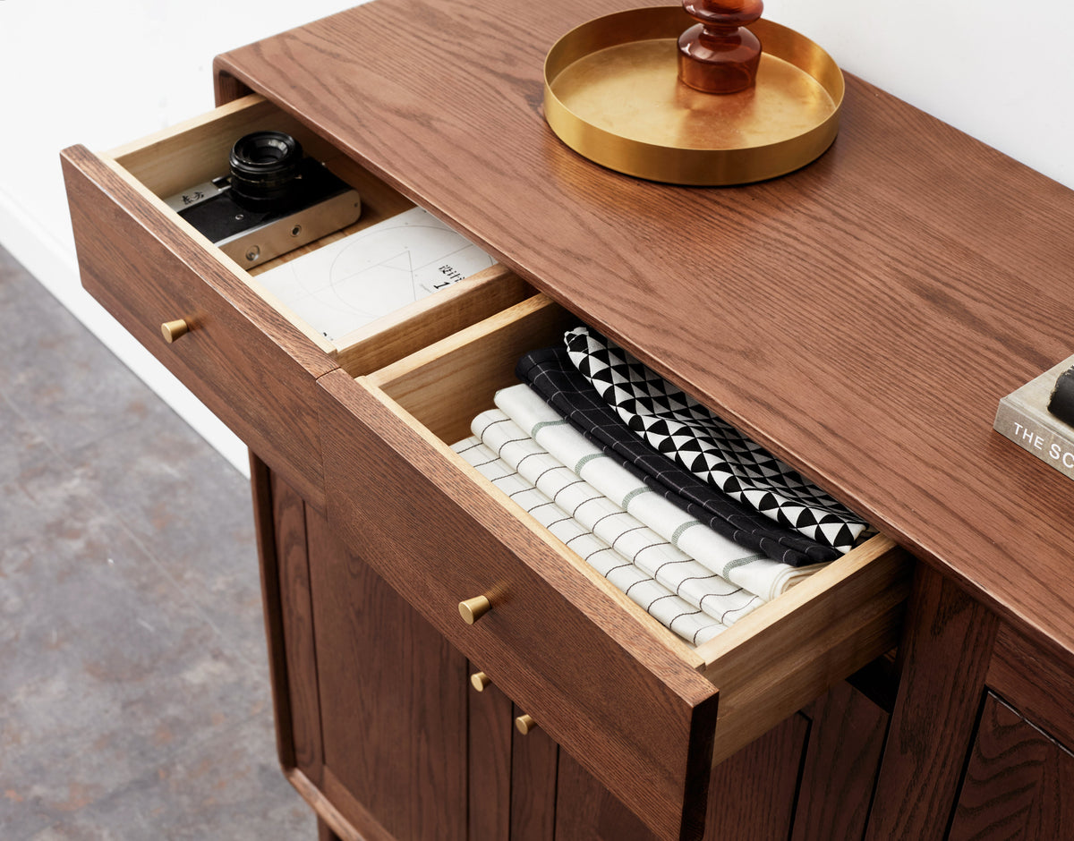 Open solid timber drawers showing unfinished interior and brass pulls